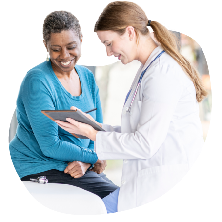 Patient and doctor looking at tablet and smiling